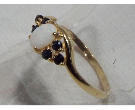 A lady's hallmarked 9 carat yellow gold opal and sapphire ring approx weight 1.39 gm (all in) size O + 1/2, boxed
