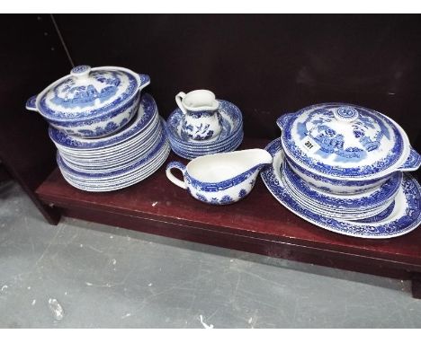A collection of ceramic tableware decorated in the blue and white Old Willows pattern to include plates, bowls, lidded tureen