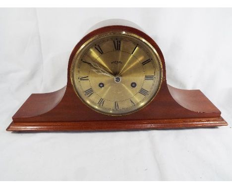 A mahogany cased Napoleon hat style mantel clock, gold finish dial signed Rotary behind opening brass bezel, hour and half pa
