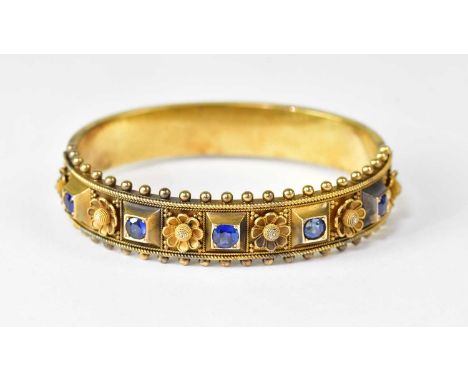 A Victorian gold-coloured metal hinged bracelet, with five sapphires in raised square mounts, with flower head between and go