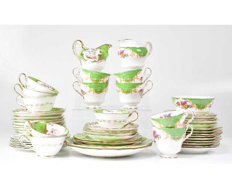 A Jackson &amp; Gosling porcelain part tea service with green and gilt floral panels, comprising cups, saucers, side plates a