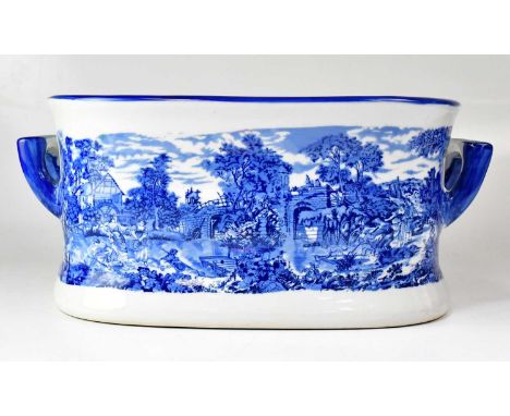 A Regency Ironstone blue and white foot bath with printed decoration depicting figures in a rural landscape, with printed mar