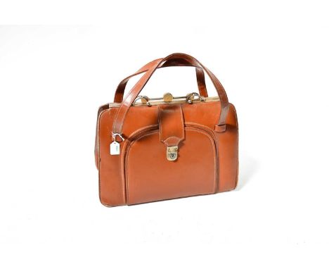 An Argentinian brown leather vanity travelling bag with metal mounts and clasp, the front section to fitted interior with mir