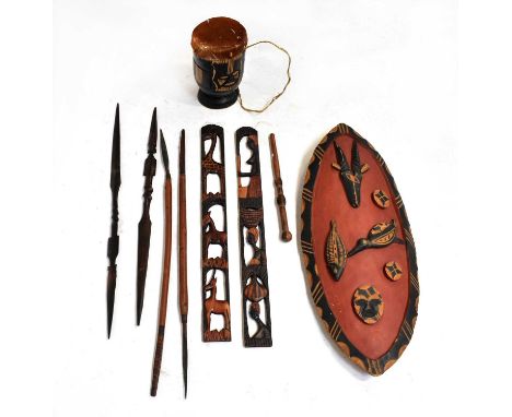 A collection of African tribal items to include a shield, a small drum, carved spearheads, etc.