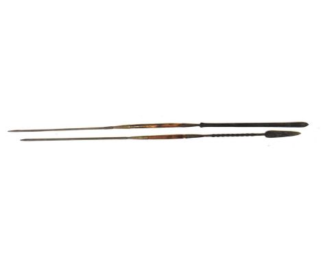 Two African double-ended spears, one with leaf-shaped spearhead and twisted metal shaft, the other with long blade, both with
