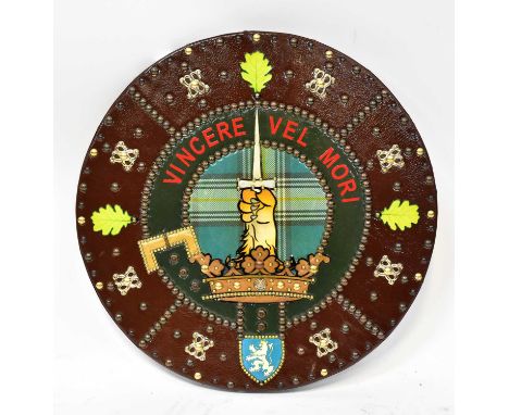 A re-enactment Medieval leather studded shield with armorial crest depicting a crown with a lion's paw holding a dagger and t