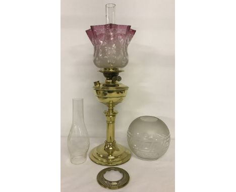 A large vintage brass oil lamp with clear and pink glass fluted shade. Complete with Chimney. Together with an extra light sh