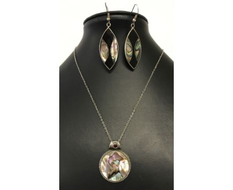 A large pendant set with paua/abalone shell and a garnet in a decorative silver mount, on a 16inch silver chain.  Together wi