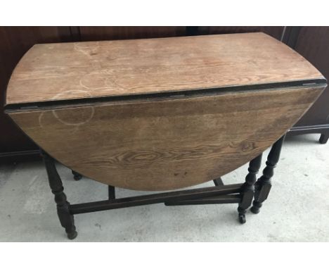 A vintage dark wood drop leaf, gate leg table with turned detail to legs.  Approx. 76cm tall x 106cm wide (unextended).