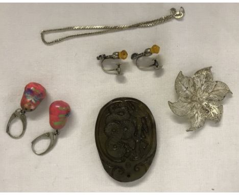 A collection of silver / jade jewellery. Comprising: A filigree silver flower brooch. A pair of Scottish thistle design, scre