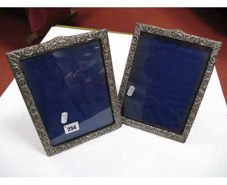 A Pair of Hallmarked Silver Mounted Photograph Frames, each detailed in relief on easel back. (2) 