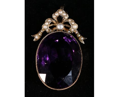Edwardian large amethyst and seed pearl pendant, the oval cut amethyst measuring 3cm x 2.1cm, suspended beneath a pearl ribbo