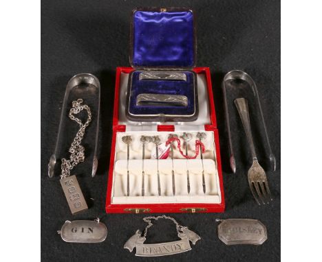 Two George III brightcut engraved silver sugar tongs, a silver cake fork, "Brandy" silver bottle label and two other labels, 