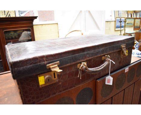A vintage crocodile suitcase, inscribed 'Finnigans...', 62.5cm wide. 