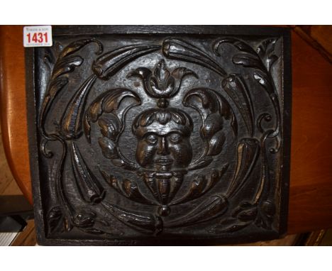 An antique carved oak panel,&nbsp;relief decorated with a central mask, 25 x 29.5cm.&nbsp; 
