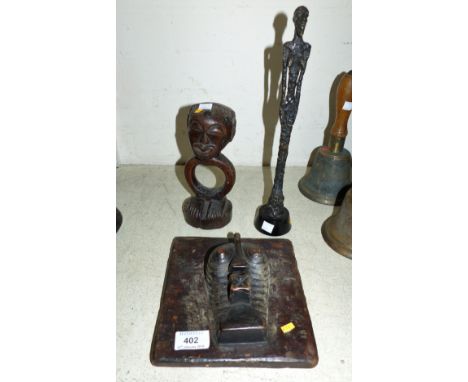 A modernist elongated bronze figure; an African tribal figure; a carved square face mask wall plaque