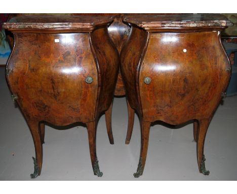 A pair of late 19th/early 20th century near matching Italian bombé dwarf commode cabinets each enclosed by a single door, wit