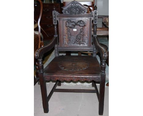 A Victorian Gothic Revival carved oak armchair with solid seat, the back panel carved with knights