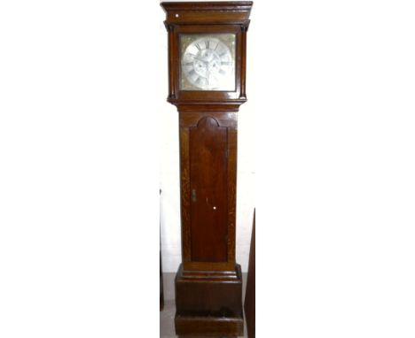 An 18th century oak long case clock, the hood with turned side pillars, arched full length door to the trunk, square brass di