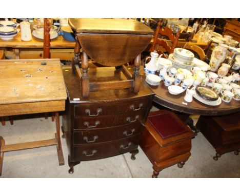 A reproduction bow front four drawer chest of small proportions; and a drop leaf coffee table