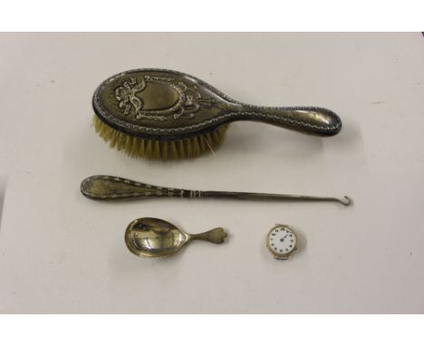 A silver caddy spoon; yellow metal cased wrist watch  AF; silver backed brush and a button hook 