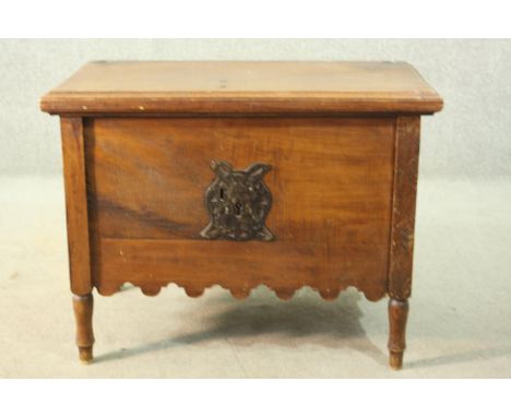A 19th century continental trunk, with a rising lid, enclosing a candle box, above an ornate iron escutcheon, over an undulat