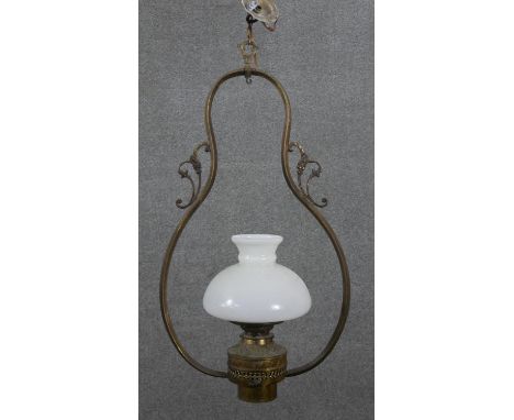 A Colonial brass hanging lamp, the frame of pear form, with a milk glass shade. H.74 W.40cm 