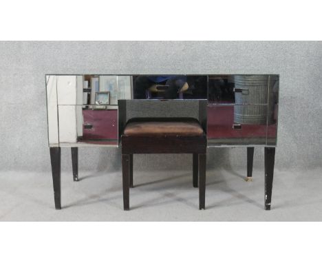 A mid 20th century mirrored kneehole dressing table, with an arrangement of five short drawers, on eboned square section tape