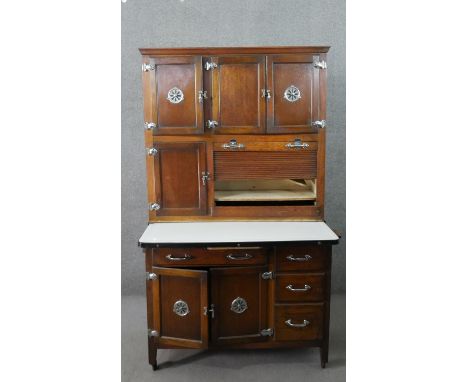 An early 20th century oak larder or pantry unit, with an arrangement of cupboard doors and drawers, including a tambour secti