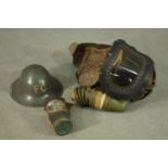 A WWII childs respirator with military issue gas mask and WWII helmet, stamped FG. H47 W.40cm. (