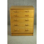 A circa 1950s utiity style chest, probably E Gomme, G-Plan, of five long graduated drawers, on a