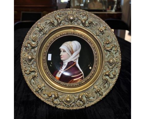 Continental hand painted ceramic portrait plaque portrait of a Woman in classical clothing, enclosed in a brass circular fram