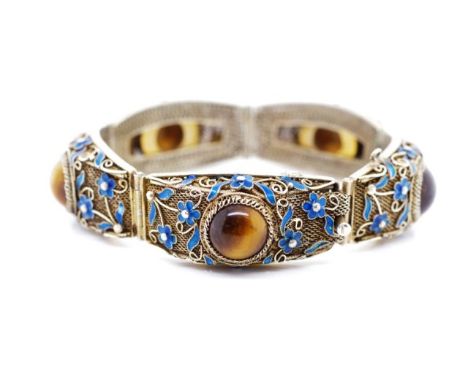Vintage Chinese silver bracelet set with tiger's eye cabochon and blue enamel flowers. The filigree body has a light gilt was