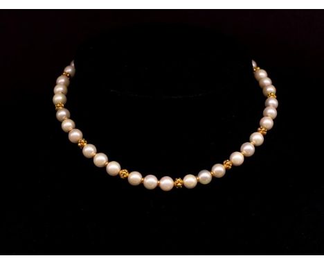 Cultured pearl and 18ct yellow gold necklace the ball clasp is marked 750. The beads tests as 18ct. Approx length 35cm