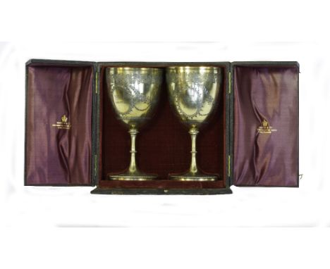 A PAIR OF SILVER GILT GOBLETS, with foliate decorations, both with heraldic crests to front, both bearing maker's mark 'D. H.