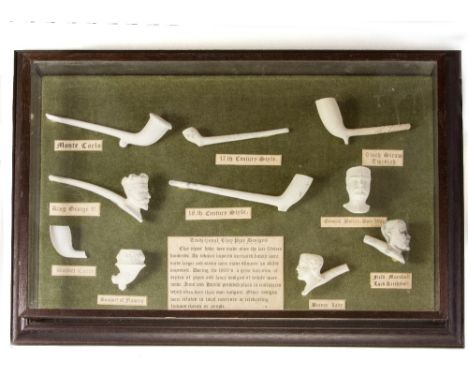 A GLAZED WALL HANGING DISPLAY CABINET CONTAINING A COLLECTION OF ASSORTED CLAY PIPES AND PIPE BOWLS, ranging from a 17th cent