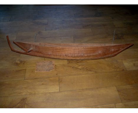 A SCALE MODEL OF A BAGANDA WAR CANOE, comprising various sections of tree planks sewn with fibres along the hull and attached