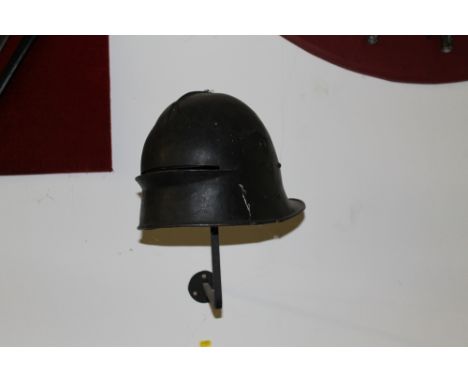 A 16TH CENTURY STYLE JOUSTING HELMET with single eye slit visor, 19th/20th century origin, H 26 cm Note: fixed on wall above 