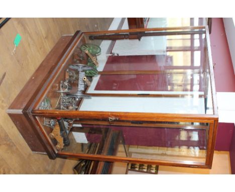 A MAHOGANY MUSEUM GLAZED DISPLAY CABINET, opening to one end, on a later plinth, H 172 cm, W 136 cm, D 62.5 cm