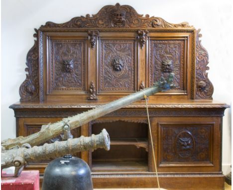 A LARGE VICTORIAN CARVED OAK SIDEBOARD, the heavily carved back featuring three panels with mask head detail, the lower secti