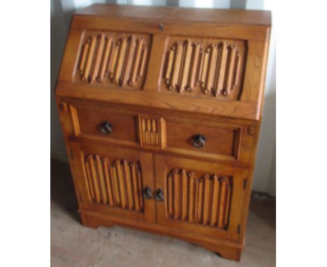 Light oak bureau, with linen fold detail, fall front with fitted interior above drawer and two doors on bracket feet, W76cm D
