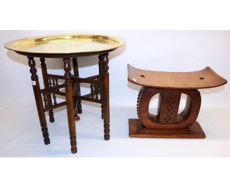 African ashanti type stool, H37cm; and a Middle Eastern style circular brass topped table with folding base, H53cm (2) 