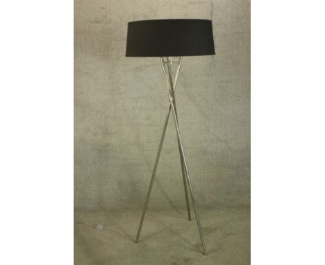 A minimalist style floor lamp with a black shade sitting on a chrome tripod. H.163cm. 