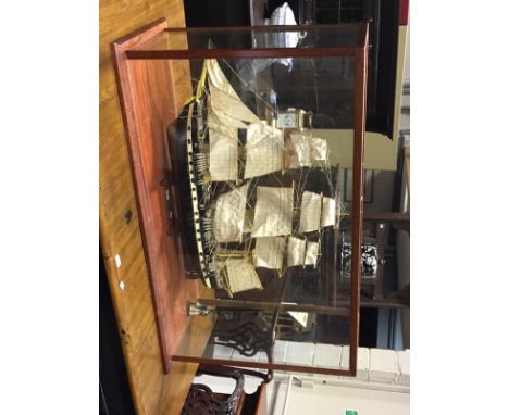 A scratch built model of a ship with full rigging, approximately 100cm long, within a glazed mahogany case, 74cm high x 121cm