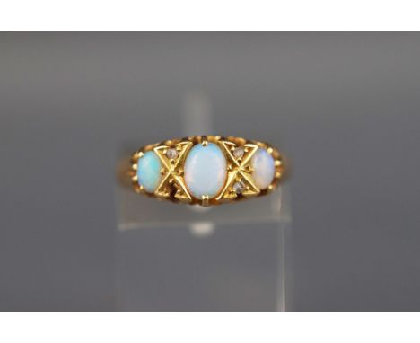 An Edwardian 18ct gold, opal and diamond ring, the three graduated oval white opals with small rose diamond points, Birmingha