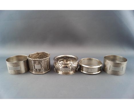 Five various napkin rings including two hallmarked examples, a pair of engine turned examples stamped '925; and an octagonal 