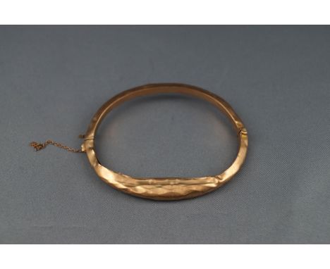 An early 20th centuy 9ct rose gold hollow knife-edge hinged bangle, (badly damaged), Birmingham 1914 by H Mathews, 8.2g.