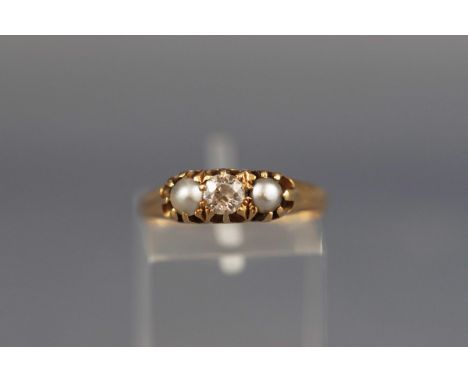 An Edwardian 18ct gold, diamond and half-pearl three stone ring, centred with an old-cut diamond between silvery-grey coloure