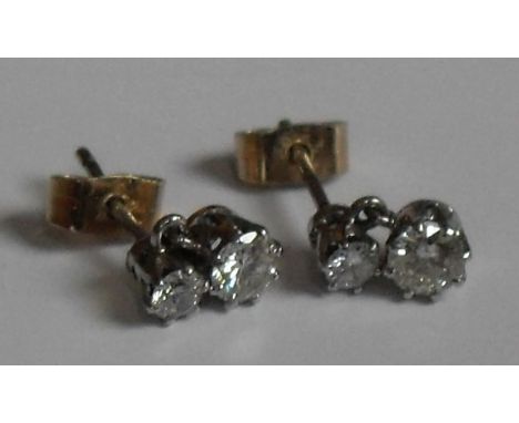 A pair of diamond stud earrings. Each set with two brilliant-cut diamonds measuring 3mm x 3.75mm in claw settings, post and s