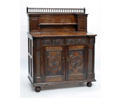 Late Victorian carved oak chiffonier the two carved drawers over two carved doors, the upper section fitted two cupboards and